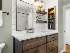 Built in storage and floating shelves complete this warm and inviting bathroom.