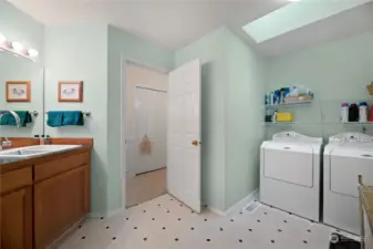 Large laundry room with a utility sink and cabinet for storage.