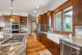 Finishing touches such as open shelving, a gas cook-top, and farmhouse sink with a high-arc faucet complete this gourmet kitchen, making it the ideal space for both everyday cooking and entertaining guests.