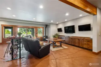 The basements includes an abundance of space for leisure, entertainment, and activity. This area boasts multiple televisions strategically placed for optimal viewing, creating a cinematic experience for sports fans or movie buffs alike.