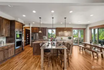 The stylish kitchen, designed for culinary creativity and entertaining, features an oversized central island, polished granite countertops, stainless steel appliances, and a custom designed walk-in pantry.