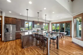 An extended seating area off the island creates a casual dining spot perfect for quick meals or social gatherings, while a connected dining room offers further space for both casual and formal dining.