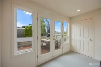 A landing at the top of the staircase leads outside to the rooftop deck.  There is a large storage closet just beside.