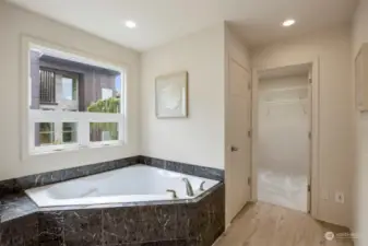 Primary bathroom also has a generous sized bathtub and a roomy walk-in closet with skylight.