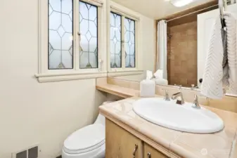 Full bath with stained-glass window.