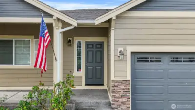 Pathway leads from driveway to covered front entry and patio.