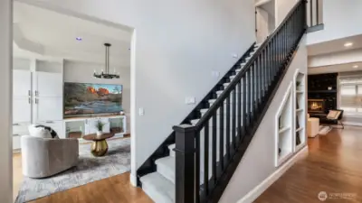 Walk into tall ceilings and a bold entry with a modern black-railed staircase and direct access to one of the home’s two spacious living areas!