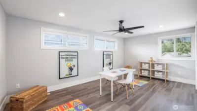 This flexible upstairs room serves perfectly as a guest bedroom, playroom, or studio, featuring hardwood floors, multiple windows, and two spacious closets