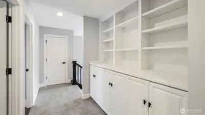 At the top of the stairs, extensive built-in shelves and cabinets provide ideal storage and organization just outside the bedrooms and bathroom, with an additional hallway closet for even more space