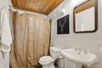 Updated main-floor full bathroom featuring tile floors and a shower.
