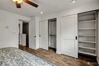 Primary bedroom double closets with custom built-in California closets.