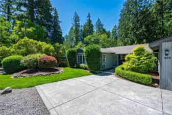 Specimen trees, rhododendrons & hedges complement the backdrop of native trees.