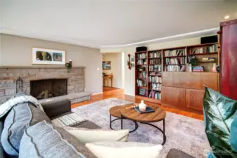 Open living and dining area with large picture windows for natural light, and a cozy wood burning fireplace.