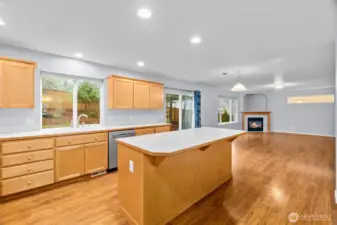Spacious kitchen with warm hardwood flooring is open to the family room and has a nice bar for casual dining, homework and more