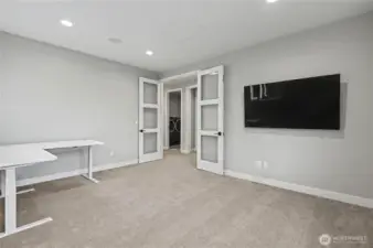 Versatile main-floor bedroom with elegant double-door entry—perfect as a guest room or sophisticated home office.