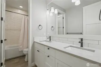 Spacious upstairs guest bath with dual sinks and a separate bath and toilet, combining style, function, and privacy.