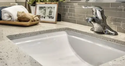 Solid surface quartz countertops with undermount sinks in the primary bath. Photos are for representational purposes only.  Colors and finishes may vary.