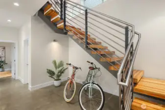 Entry level from the door or garage.  Has also been a sitting area.  Adjacent elevator services all floors. Custom-designed steel and recycled wood beam staircase seamlessly flows on all floors.