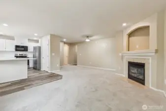 Living room and kitchen, including counter height breakfast bar and gas fireplace with tv nook.