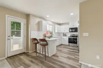 Kitchen and exit to rear deck. Virtually staged.