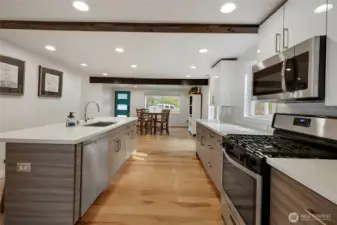 The massive island is capped with quartz and the stainless steel appliance package comes complete with a high-end gas range and ultra-quiet dishwasher by Bosch.