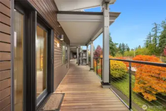 The view from the front entrance shows the covered walkway, colorful landscaping and modern details of the building exterior.