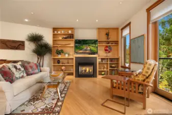 Built in book cases surround the propane burning fireplace to create a cozy space to enjoy the ever changing views of the gardens.