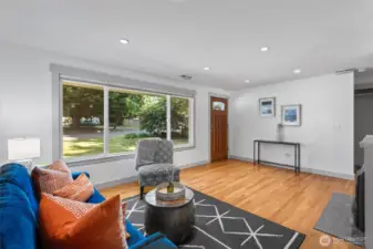 Freshly painted and filled with light, the front room features rich hardwood floors, large windows, and a cozy gas fireplace—an inviting space to relax or entertain.