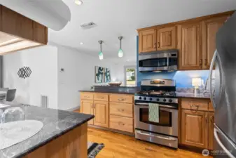 The galley kitchen is equipped with a gas cooktop and sleek stainless steel appliances—blending style and function for everyday cooking.