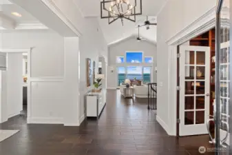 Step into a dramatic entryway where high ceilings, radiant light, and panoramic views set the tone for lakeside luxury.