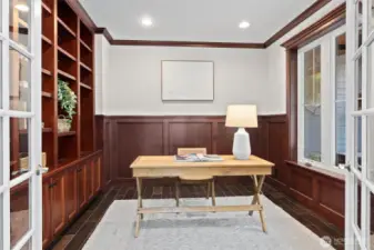 An executive-style office with handsome custom wood built-ins provides a polished, private space to work or study.