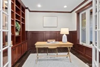 An executive-style office with handsome custom wood built-ins provides a polished, private space to work or study.