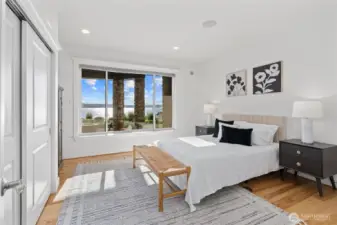 This spacious lower-level bedroom is filled with natural light and captures stunning lake views from oversized windows.