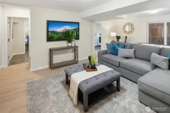 Another view of the basement recreation/bonus room with access to the basement apartment in the left background.