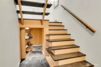 Hidden. Storage under stairs behind book case.  Potential wine cellar.
