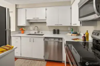 Cabinets freshly painted with new quartz counters that work well with the lively orange floor.