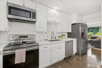 Sleek Kitchen with White Cabinets and Designer Tile Backsplash.