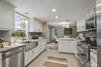 Remodeled kitchen featuring rough-cut granite countertops, tile backsplash, and tile flooring.
