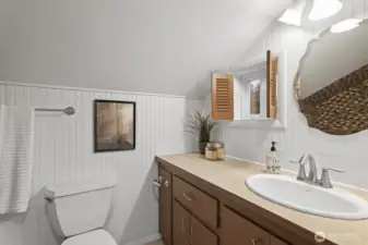 Adorable upstairs full bath featuring custom shutters and tile shower/tub surround and flooring.
