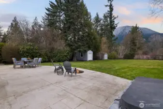 Expansive stone patio spanning the length of the home, complete with a custom fire pit and hot tub.
