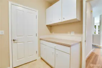 The back door leads into the garage with no steps! Remember, this is truly a one-level home. Fold laundry on the countertop and tuck cleaning supplies and other odds and ends into the cupboards. There's also a closet in the hallway for storage.