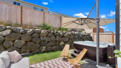 The outdoor rug is on top of an oversized aggregate patio, the perfect place for lounging or entertaining guests. The spa is nearly new, and it's inviting you to let your cares melt away. It's staying for your enjoyment!