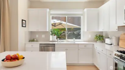 You'll love the big window over the kitchen sink, perfect for looking out at the back yard -- and all the natural daylight lets houseplants thrive!