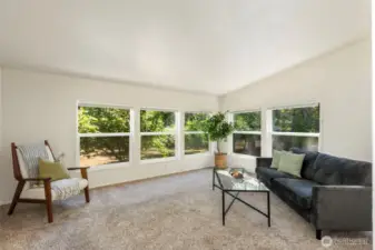 Large windows on two wall in living room provide natural light and a view to the orchard.