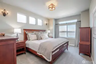 Wake up to panoramic water views right from your serene and sunlit primary bedroom retreat.