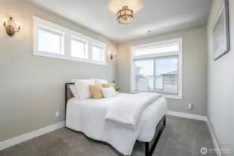 Wake up to tranquil water views and soft natural light in this cozy, serene bedroom retreat.