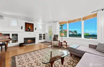 This photo shows the built-in bookcases and the wood burning, mantled & hearth fireplace adding beautiful period touches to this vintage Craftsman home. There are hardwood floors throughout this home. The fireplace is also plumbed for gas should you wish to have a gas-burning fireplace.
