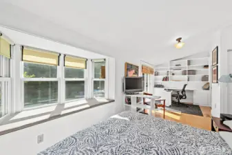 The primary bedroom is large and comfortable with a walk-in closet and a bath at hand. The area at the far side of this photo can serve as a home office or yoga & exercise space.