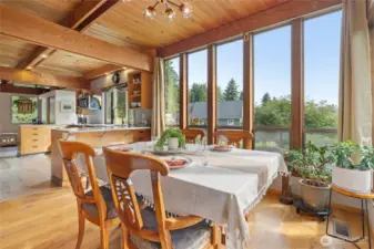 Dining open to kitchen with floor to ceiling windows