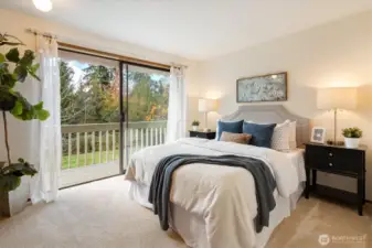 A serene main floor bedroom with sliding doors that open directly to pastoral views of lawn and treetops creating a quiet place to begin and end each day.